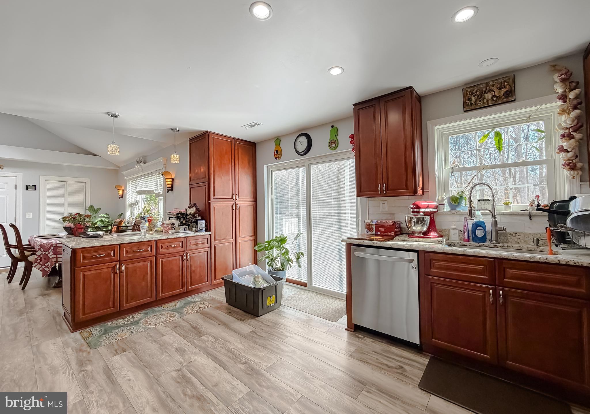30150 Huntt Road Mechanicsville, MD 20659 - Photo 21 of 40 a kitchen with stainless steel appliances granite countertop wooden cabinets a sink a stove a dining table and chairs