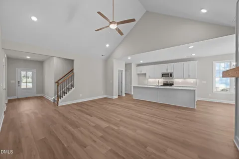 a view of a big room with wooden floor a fireplace and windows
