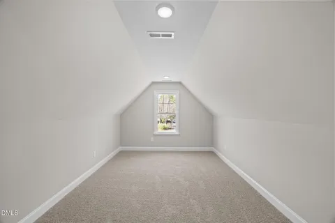 a view of street with yard and trees in the background