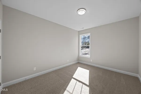 a view of an empty room and kitchen with ceiling fan wooden floor and a kitchen