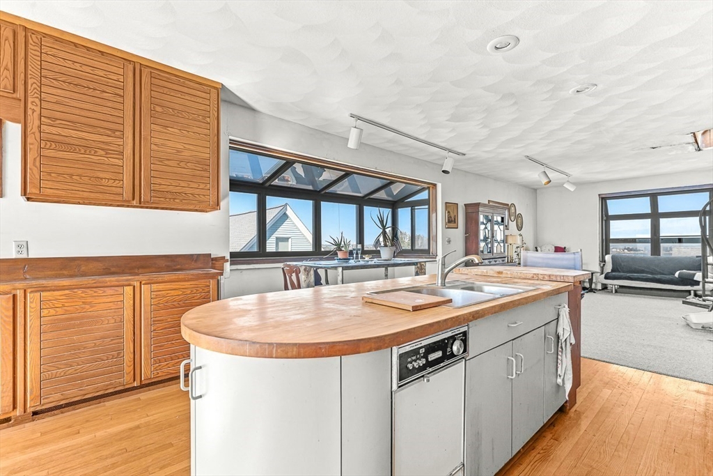 47 Prospect Avenue, Unit 47 Winthrop, MA 02152 - Photo 15 of 31 a kitchen with stainless steel appliances granite countertop a sink and a wooden floor