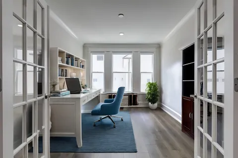 a view of a workspace with furniture and a window