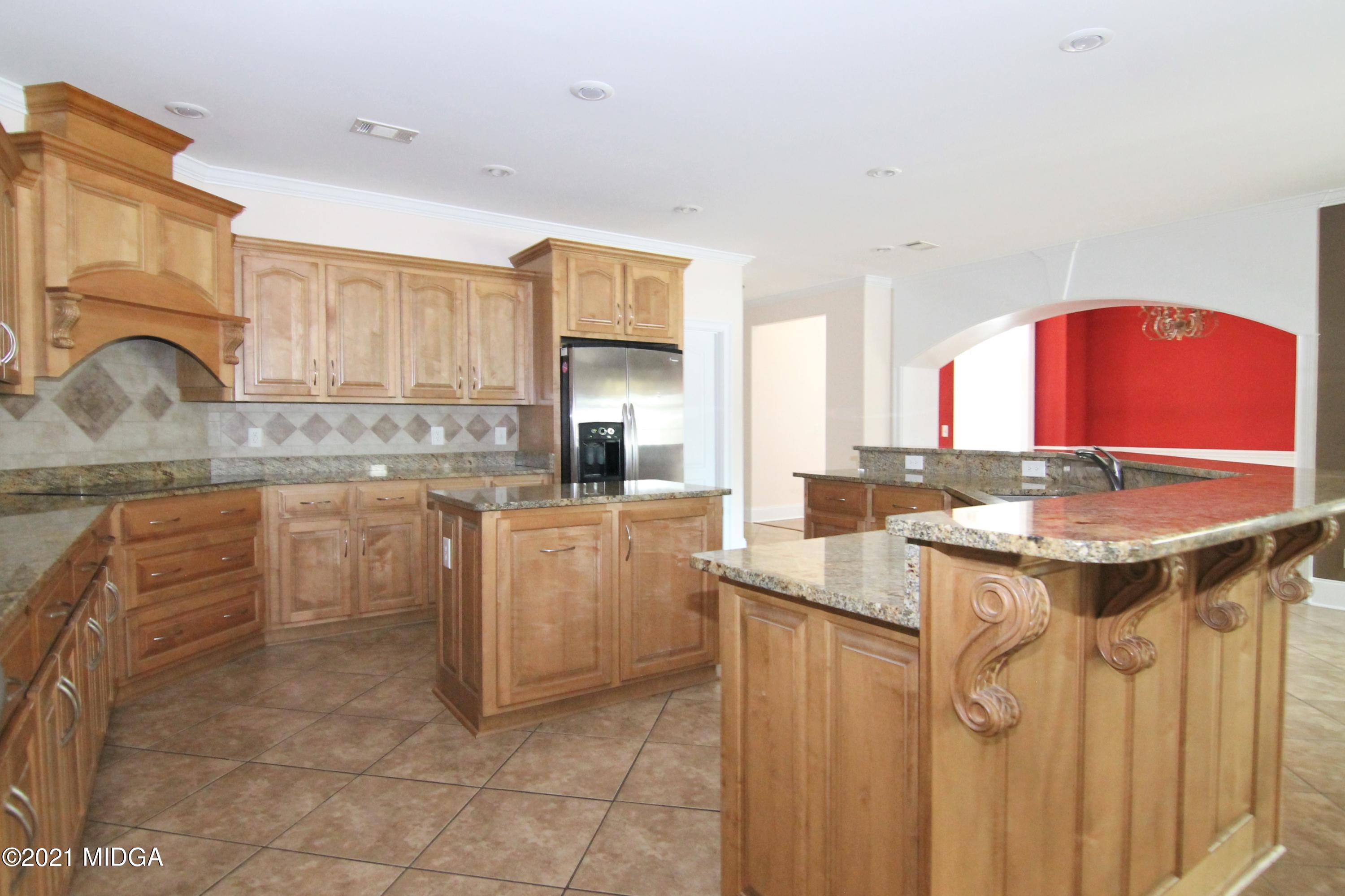 629 Toomer Road Perry, GA 31069 - Photo 12 of 59 a kitchen with kitchen island granite countertop a sink stove and cabinets