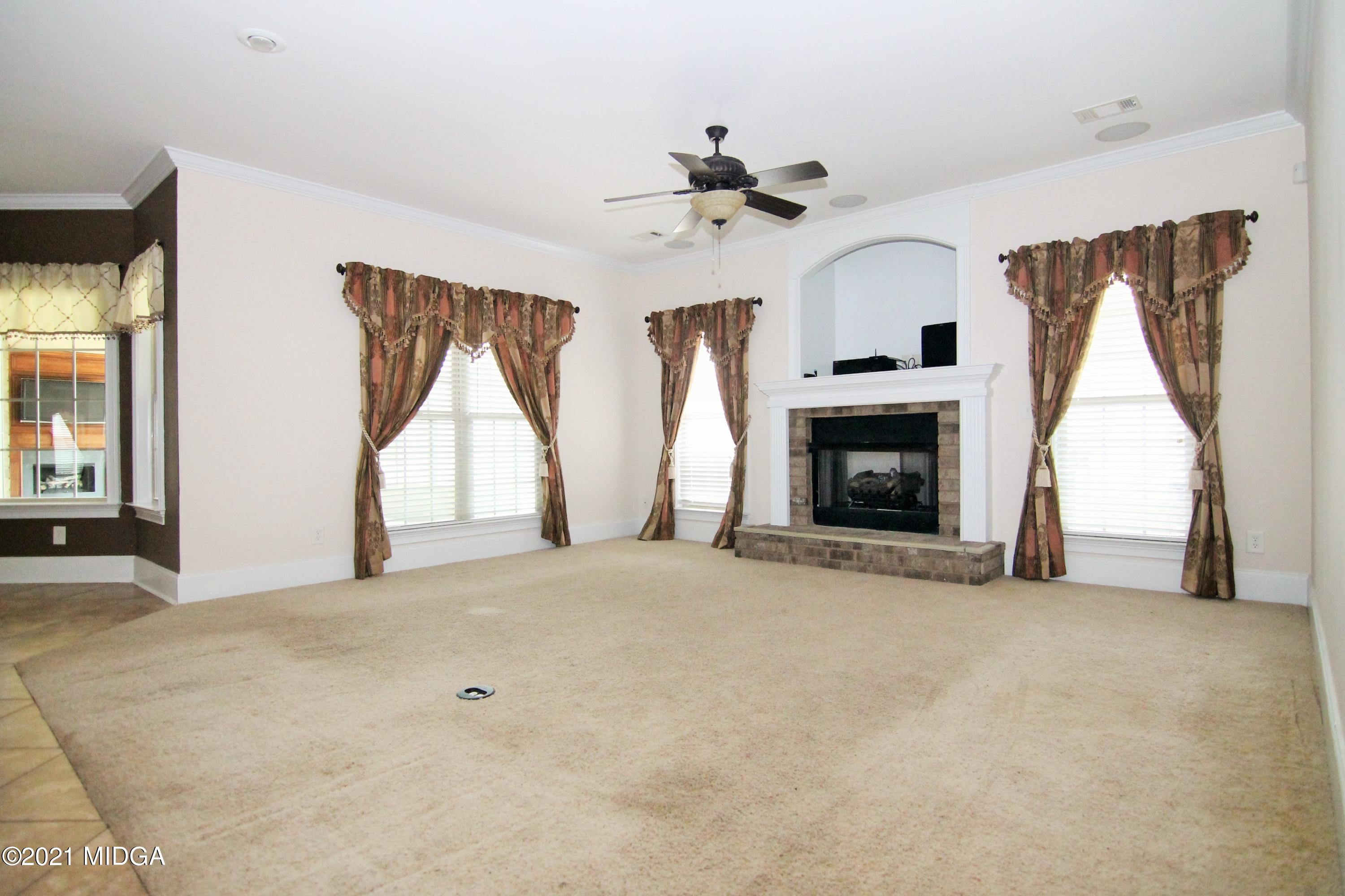 629 Toomer Road Perry, GA 31069 - Photo 15 of 59 a view of empty room with fireplace and windows