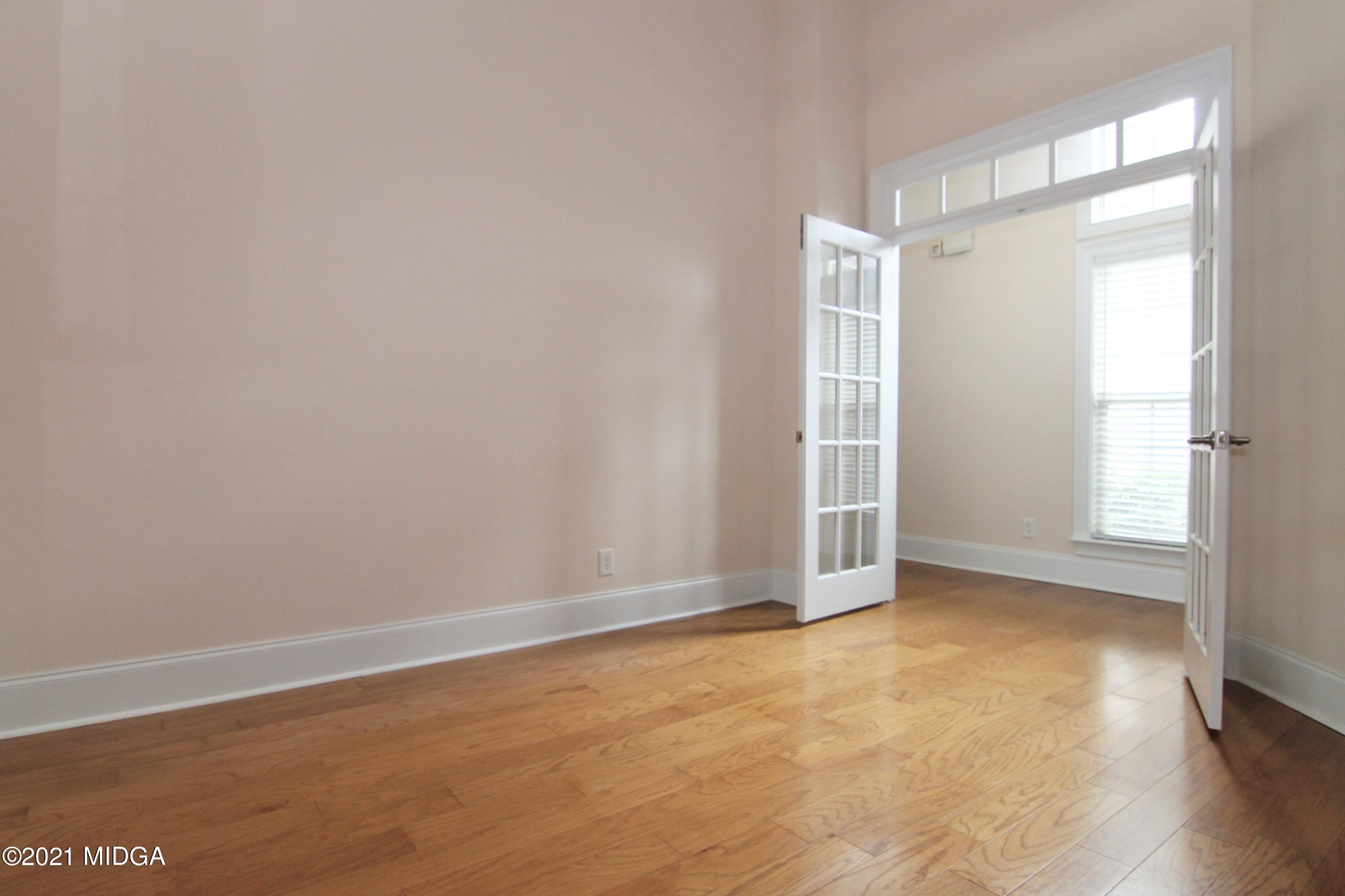 629 Toomer Road Perry, GA 31069 - Photo 18 of 59 a view of an empty room with wooden floor and a window