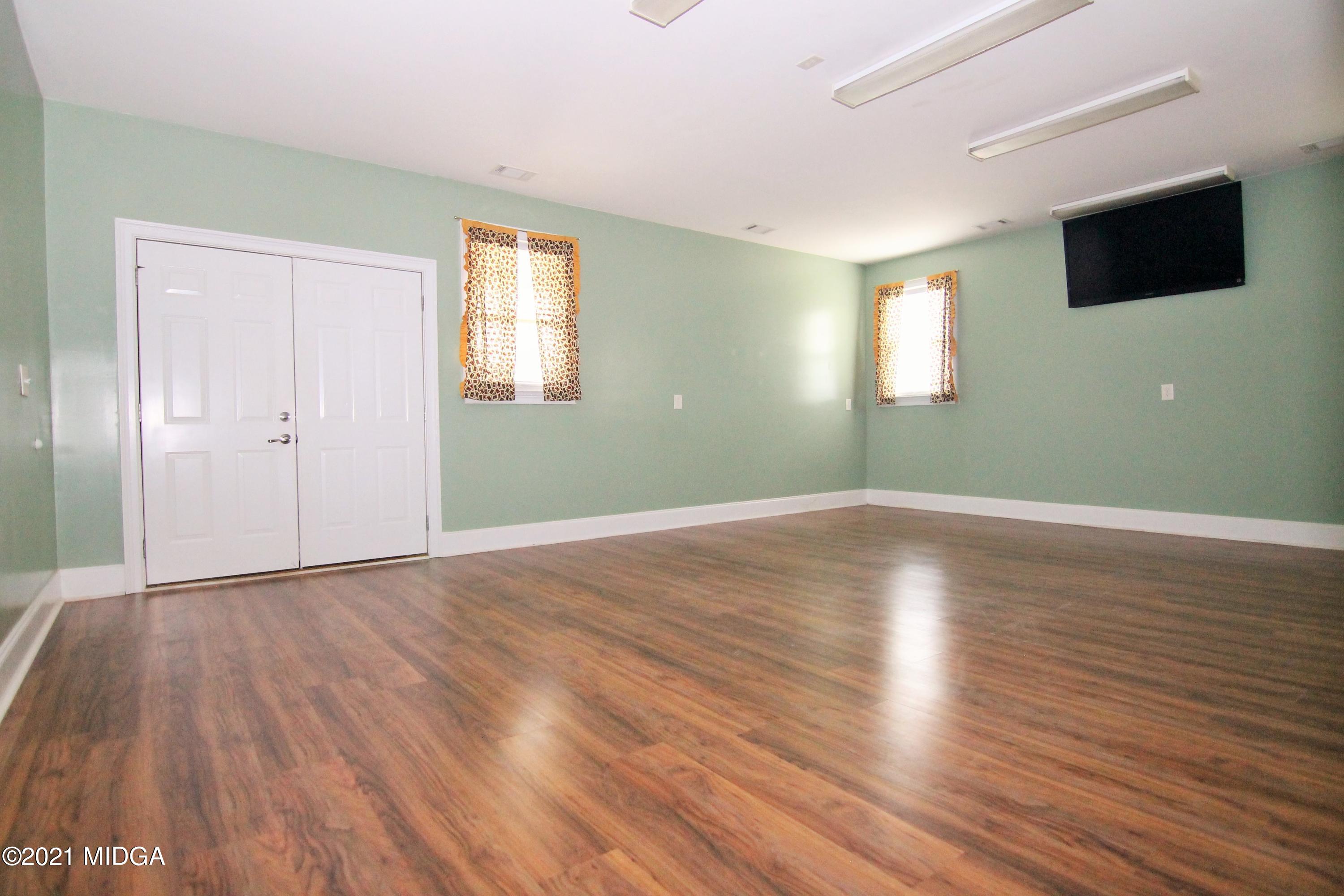 629 Toomer Road Perry, GA 31069 - Photo 29 of 59 an empty room with wooden floor and windows