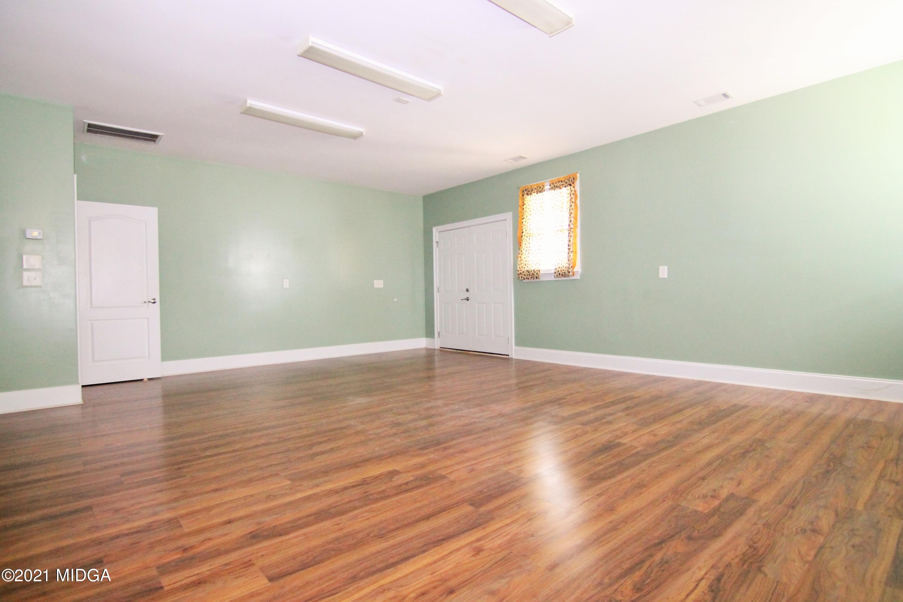 629 Toomer Road Perry, GA 31069 - Photo 30 of 59 an empty room with wooden floor and windows