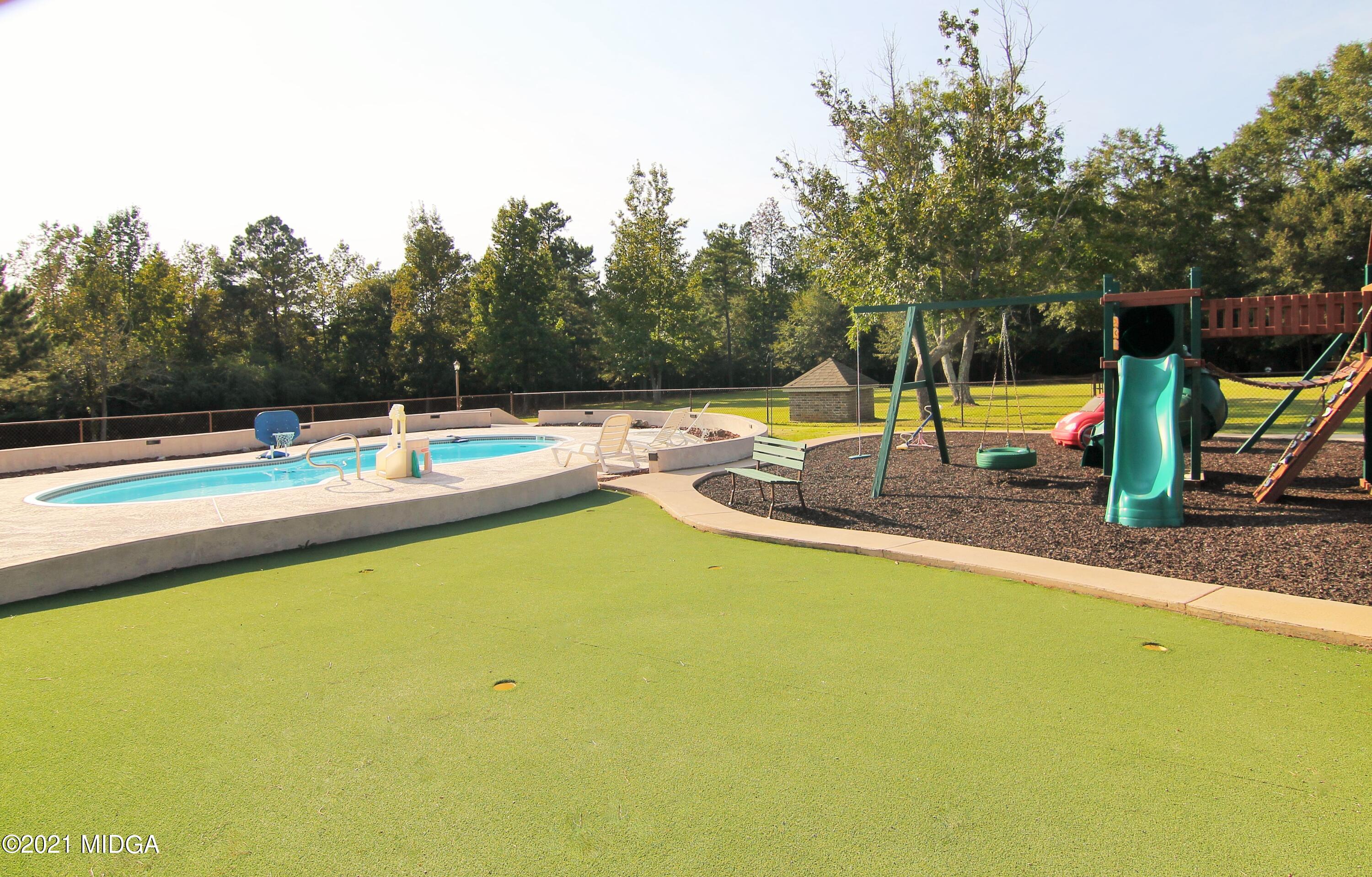 629 Toomer Road Perry, GA 31069 - Photo 54 of 59 a view of a swimming pool with a bench and trees in the background