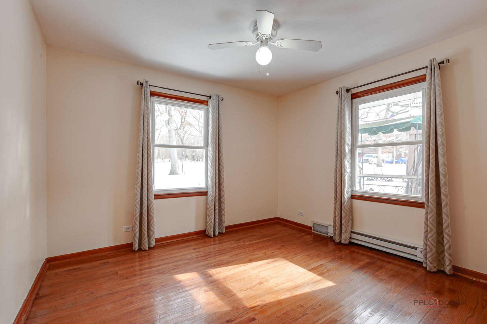 15983 West Wadsworth Road Wadsworth, IL 60083 - Photo 12 of 33 an empty room with wooden floor chandelier fan and windows