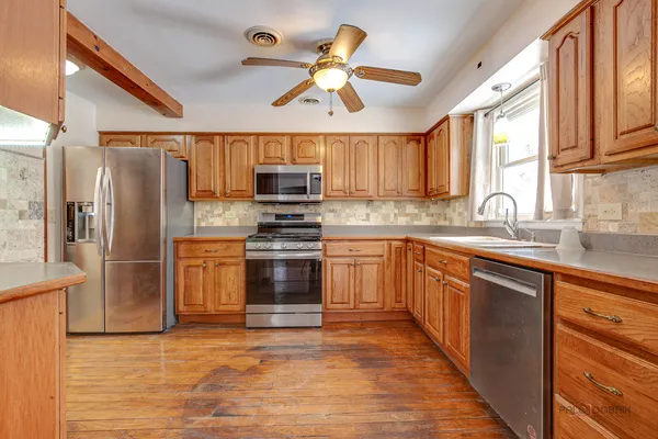 a kitchen with kitchen island granite countertop a stove a sink and a refrigerator