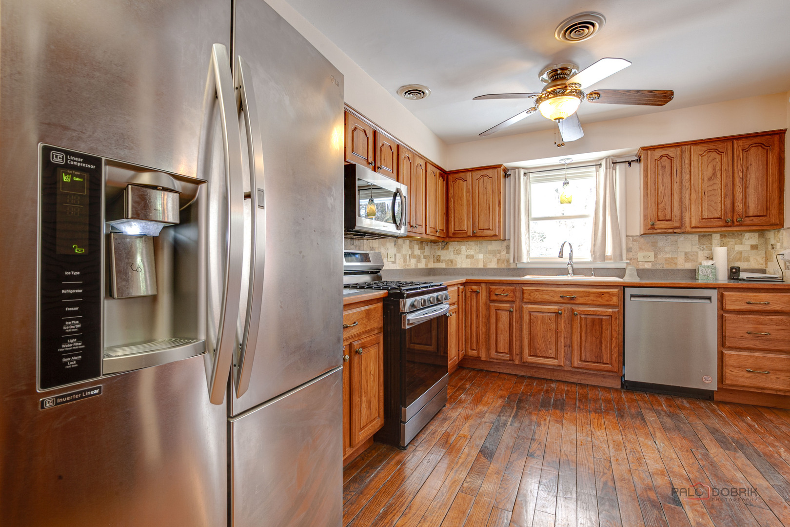15983 West Wadsworth Road Wadsworth, IL 60083 - Photo 7 of 33 a kitchen with a refrigerator a sink and dishwasher with wooden floors