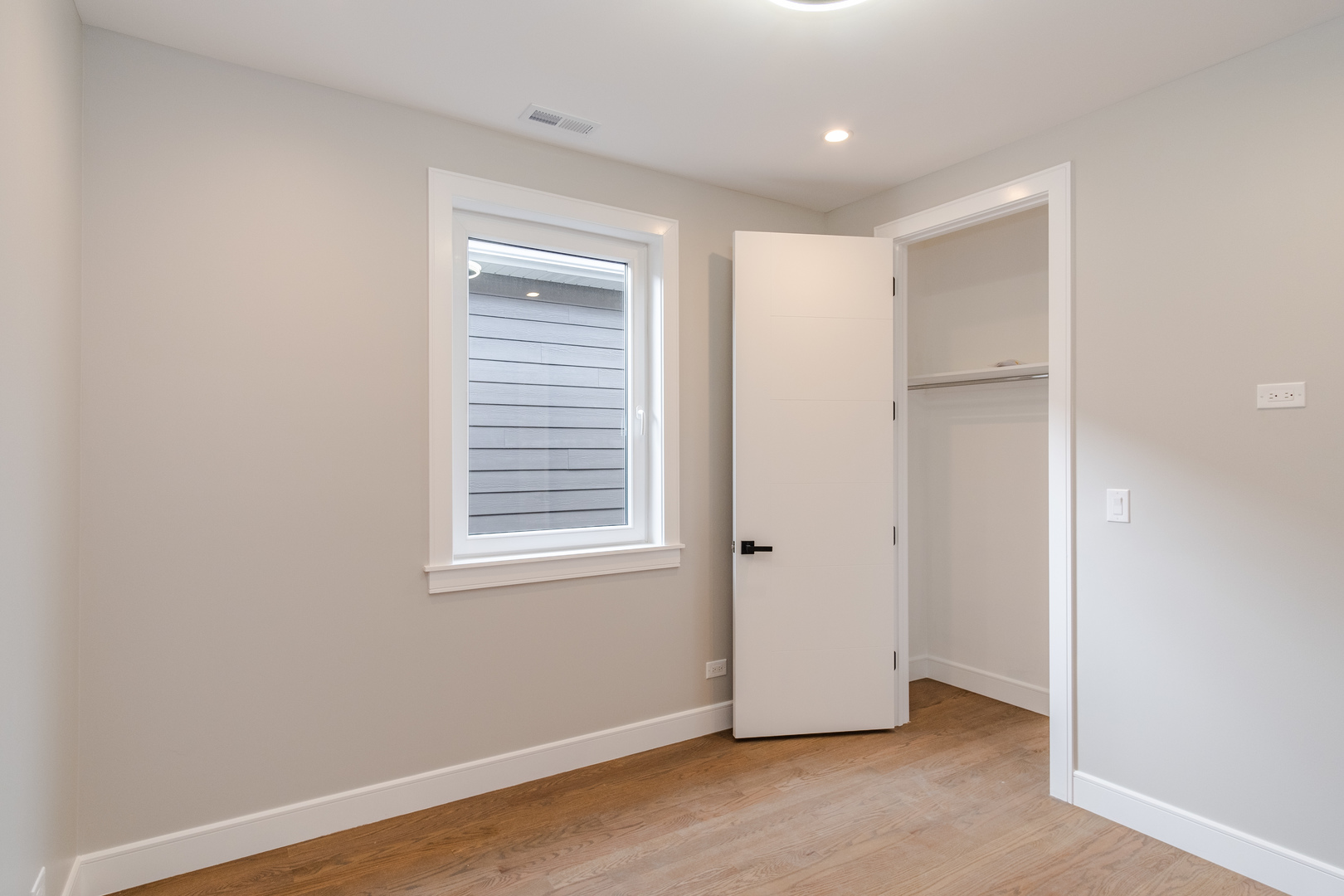 4639 South Indiana Avenue Chicago, IL 60615 - Photo 13 of 24 a view of an empty room with wooden floor and a window