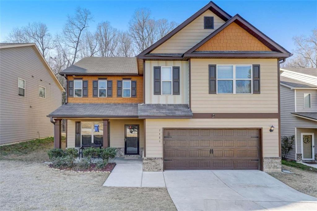 a front view of a house with yard and parking