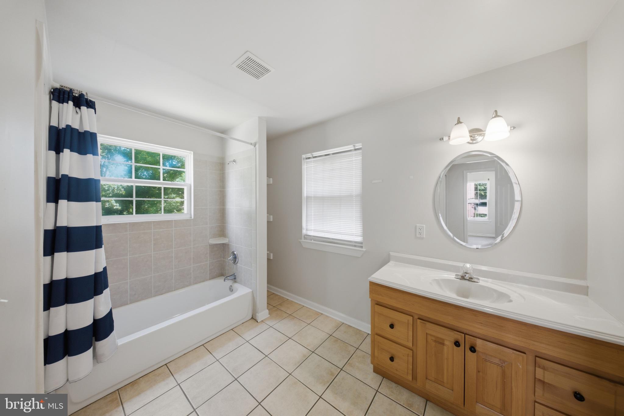 7611 Temple Hill Road Temple Hills, MD 20748 - Photo 19 of 25 a bathroom with a sink a large mirror and a bathtub
