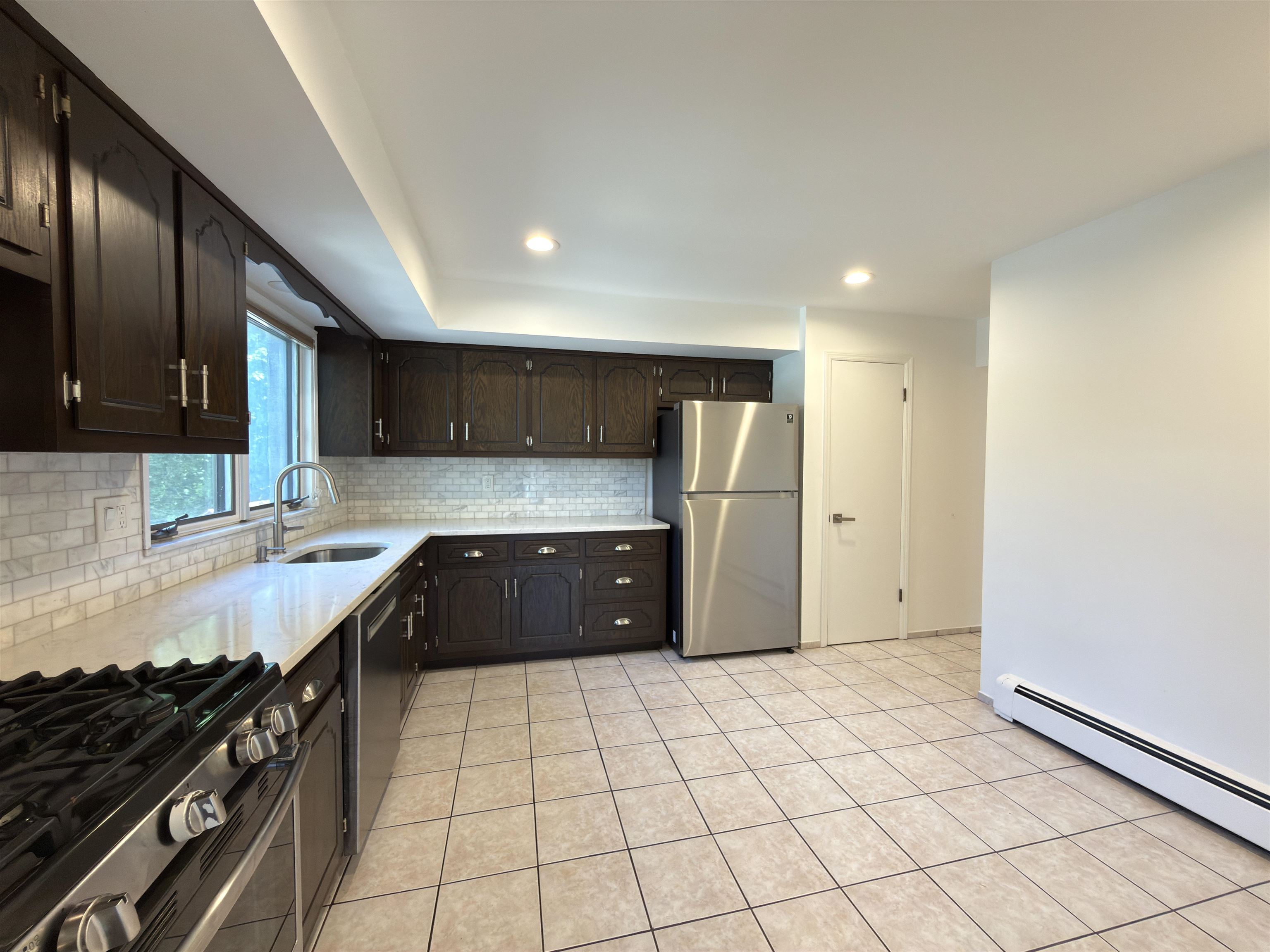 531 Day Avenue, Unit 1 Ridgefield, NJ 07657 - Photo 17 of 32 a kitchen with granite countertop a refrigerator and a stove top oven