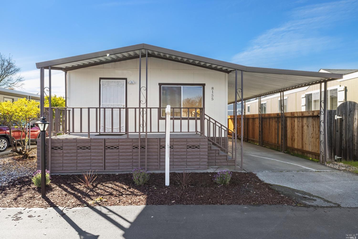 a view of a house with a floor to ceiling window and wooden fence