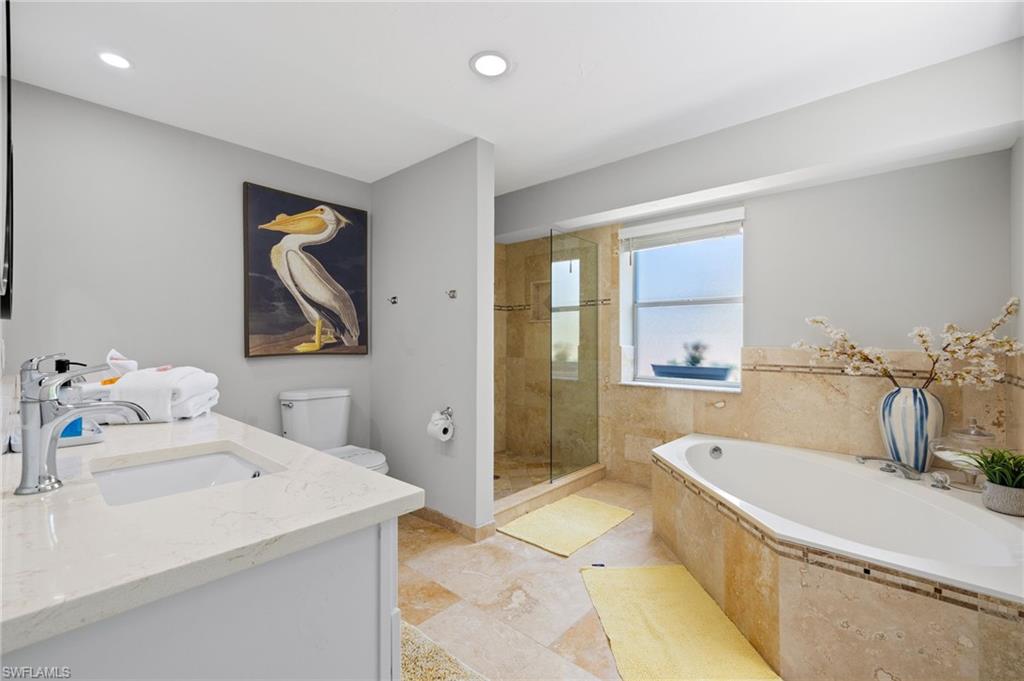482 Trade Winds Avenue Naples, FL 34108 - Photo 16 of 26 a spacious bathroom with a tub sink and mirror