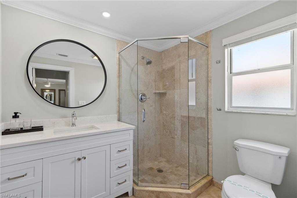 482 Trade Winds Avenue Naples, FL 34108 - Photo 18 of 26 a bathroom with a toilet a sink and a mirror