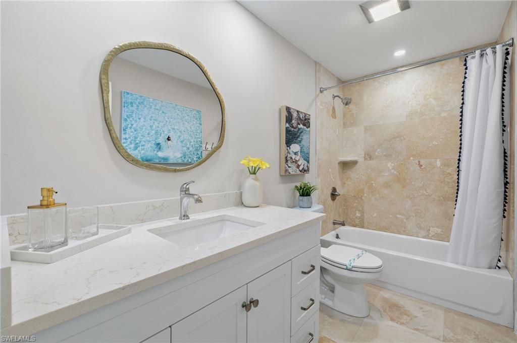 482 Trade Winds Avenue Naples, FL 34108 - Photo 20 of 26 a bathroom with a sink a toilet and a mirror