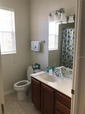 a bathroom with a sink a toilet and a window