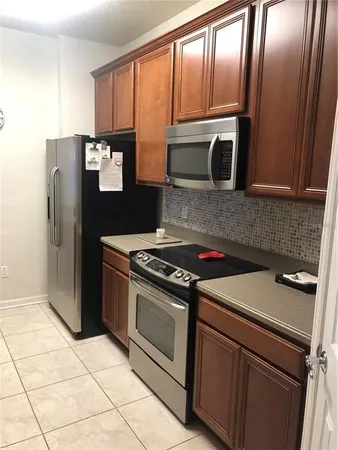 a kitchen with granite countertop a refrigerator stove and microwave