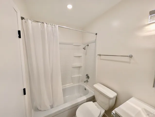 a bathroom with a shower curtain and a toilet