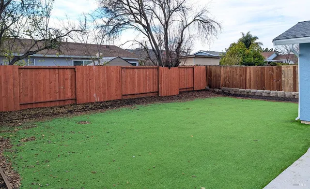a view of a backyard with wooden fence