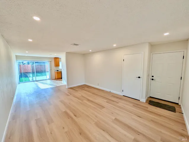 a view of an empty room with wooden floor