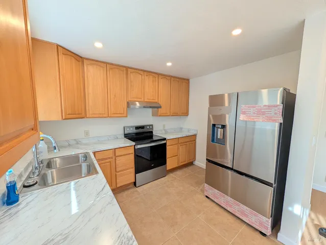 a kitchen with stainless steel appliances granite countertop a refrigerator sink and cabinets
