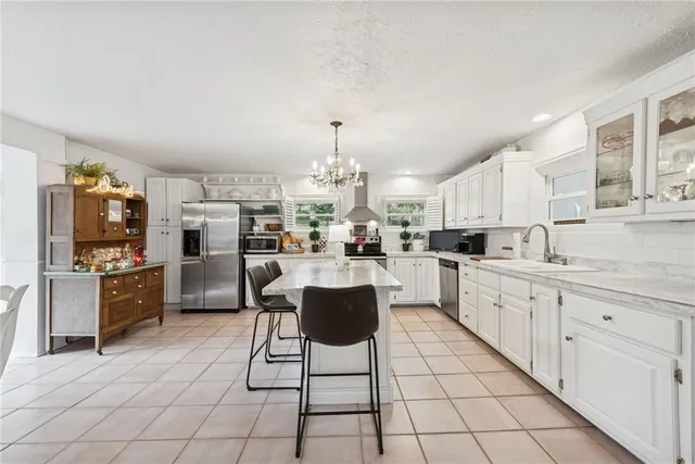 a kitchen with stainless steel appliances kitchen island granite countertop a sink and cabinets