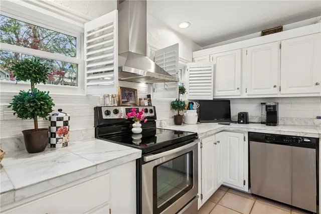 a kitchen with a stove and white cabinets