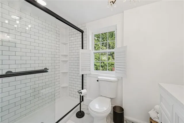 a bathroom with a toilet and a shower