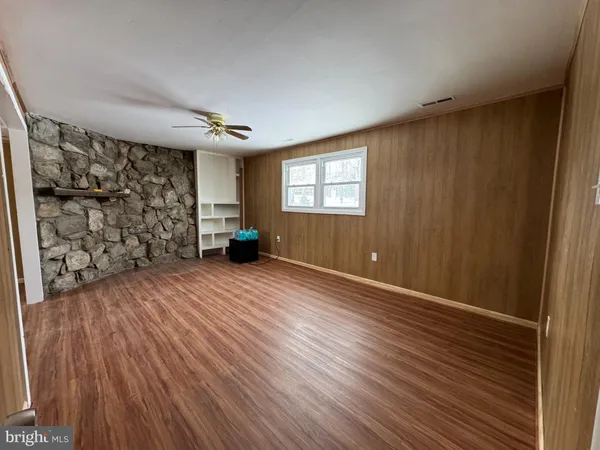 a view of empty room with wooden floor and window