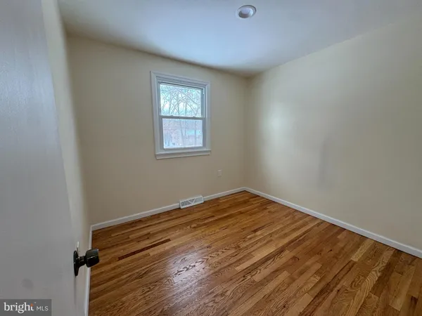 a view of room with wooden floor and fan