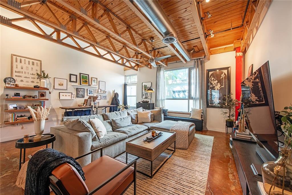 1661 La France Street Northeast, Unit 325 Atlanta, GA 30307 - Photo 13 of 40 a living room with furniture a flat screen tv and a floor to ceiling window