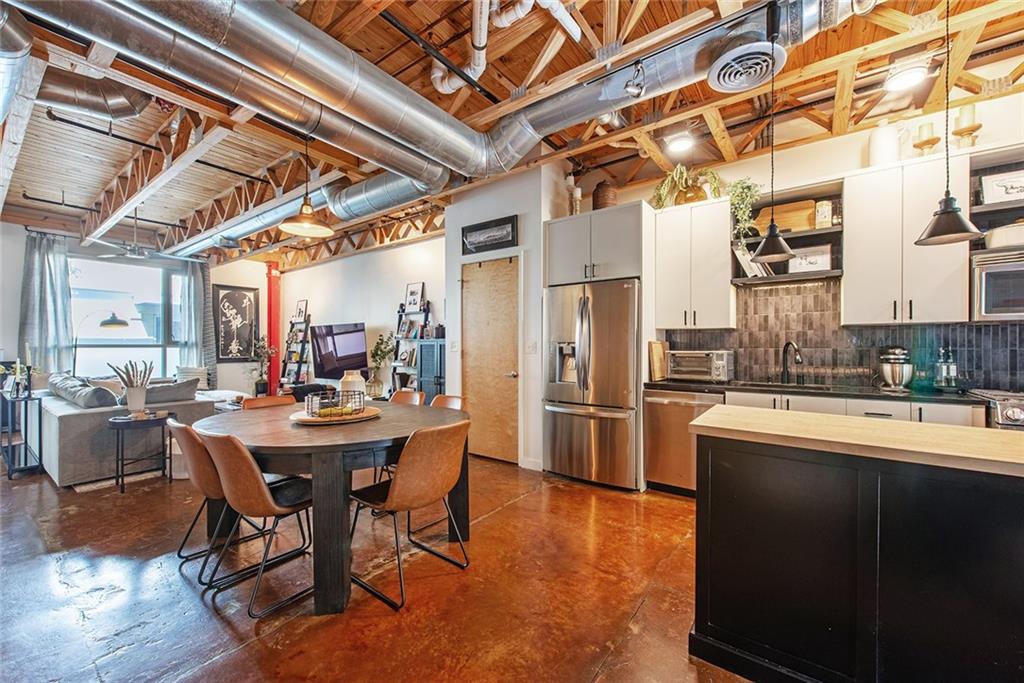 1661 La France Street Northeast, Unit 325 Atlanta, GA 30307 - Photo 15 of 40 a kitchen with stainless steel appliances a dining table chairs and wooden floor