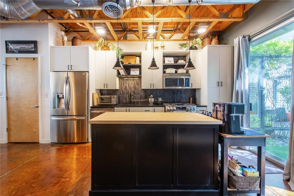 1661 La France Street Northeast, Unit 325 Atlanta, GA 30307 - Photo 18 of 40 a kitchen with stainless steel appliances granite countertop a sink and a refrigerator