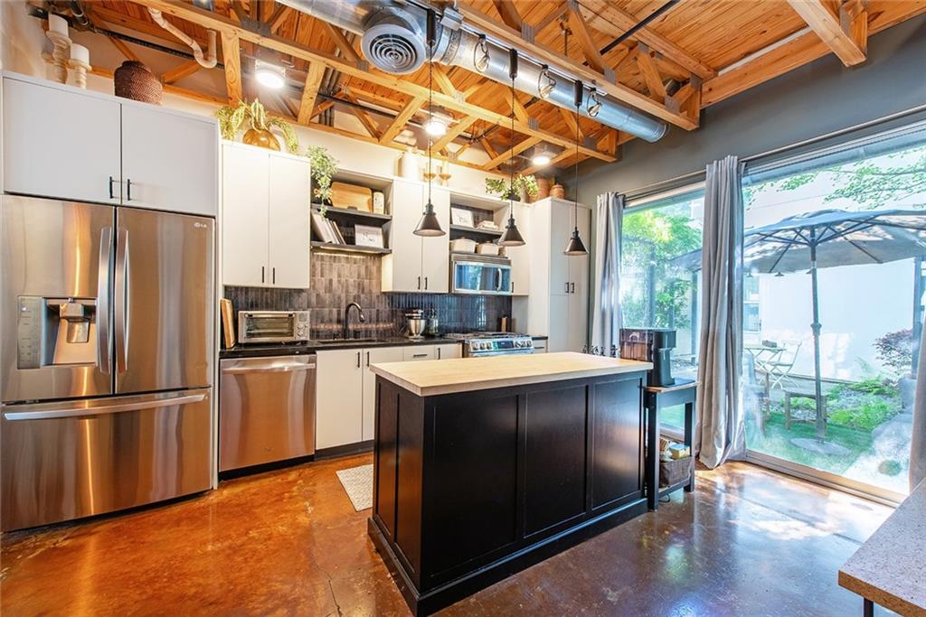 1661 La France Street Northeast, Unit 325 Atlanta, GA 30307 - Photo 19 of 40 a kitchen with stainless steel appliances granite countertop a refrigerator a stove and a refrigerator