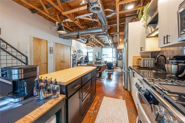 a kitchen with stainless steel appliances granite countertop a stove a sink dishwasher and cabinets with wooden floor