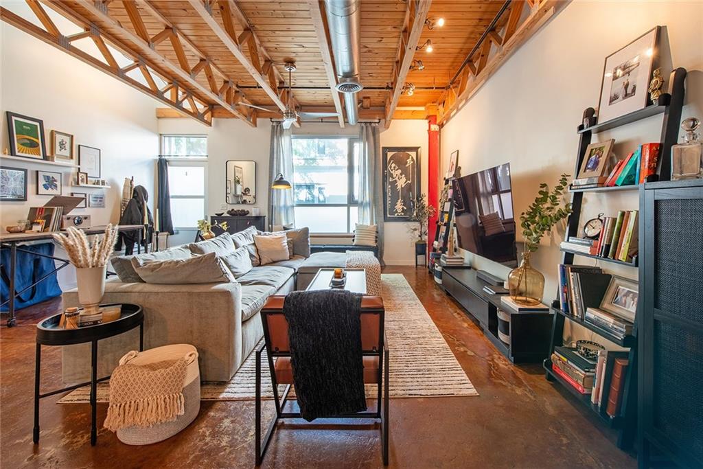 1661 La France Street Northeast, Unit 325 Atlanta, GA 30307 - Photo 10 of 40 a living room with furniture a flat screen tv and a book shelf