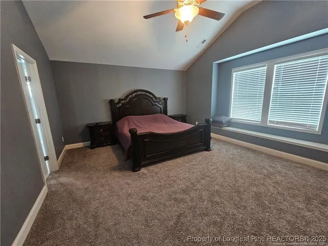 a spacious bedroom with a bed and a chandelier