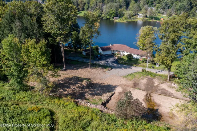 an aerial view of a house with a yard and lake view
