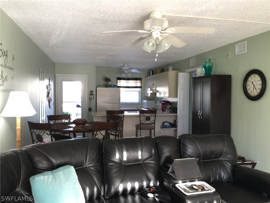 26485 Rampart Boulevard, Unit E3 Punta Gorda, FL 33983 - Photo 11 of 22 a living room with furniture kitchen view and a chandelier