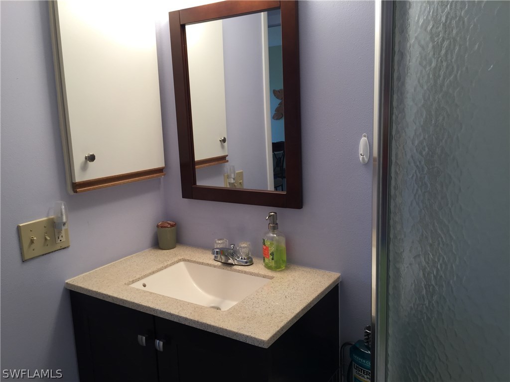 26485 Rampart Boulevard, Unit E3 Punta Gorda, FL 33983 - Photo 13 of 22 a bathroom with a sink and a mirror