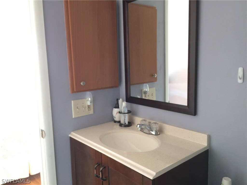 26485 Rampart Boulevard, Unit E3 Punta Gorda, FL 33983 - Photo 17 of 22 a bathroom with a sink vanity and a mirror