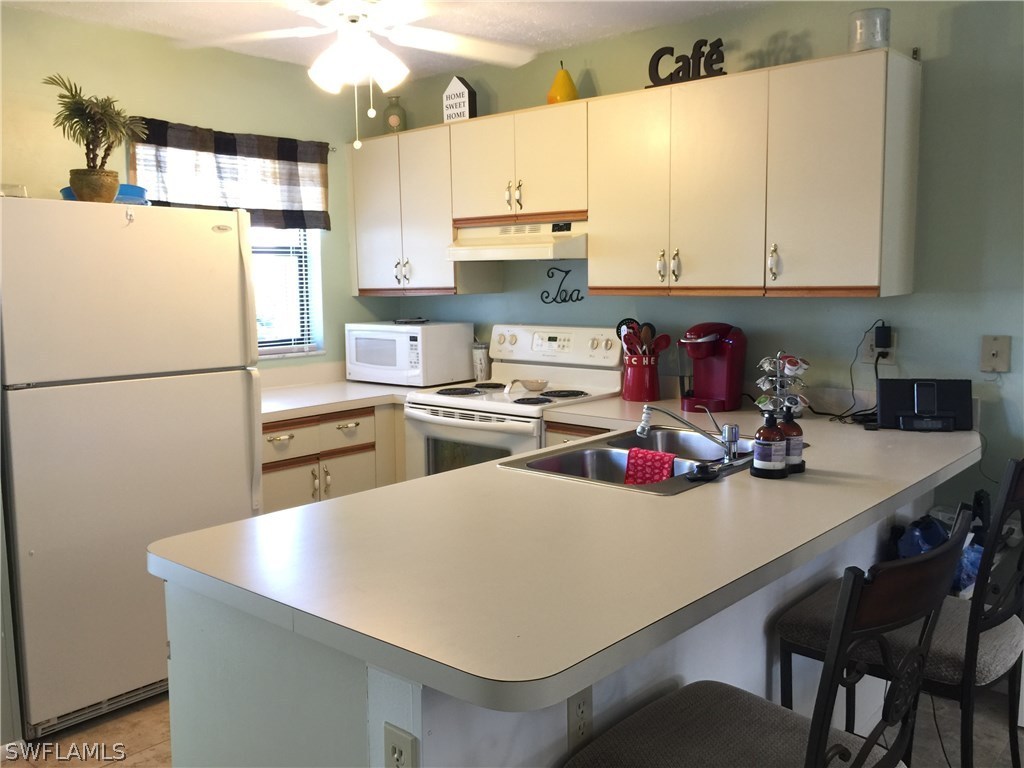 26485 Rampart Boulevard, Unit E3 Punta Gorda, FL 33983 - Photo 7 of 22 a kitchen with a refrigerator a stove a sink and a refrigerator