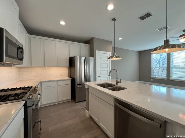 a kitchen that has a sink stainless steel appliances and cabinets