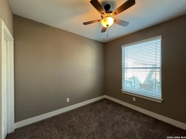 an empty room with a window and a fan