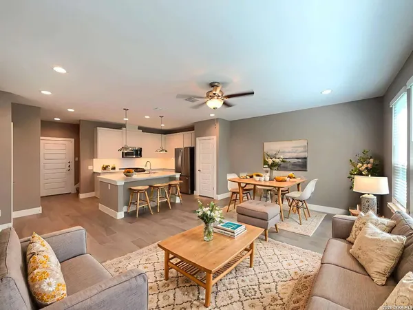 a living room with furniture kitchen view and a chandelier