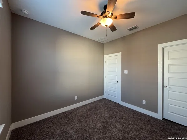 an empty room with a ceiling fan and a window